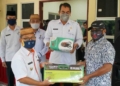 Wabup Gorontalo Utara Thariq Modanggu menyerahkan bantuan usaha kepada masyarakat didampingi Kadis Dinas Nakertrans Gorontalo Utara. (foto:hms)