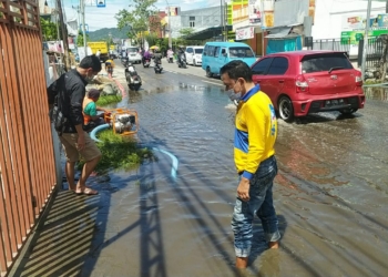 Penyedotan air yang menggenangi jalan HB.Yasin Kota Gorontalo oleh Dinas PUPR, Ahad (22/5/2021).(f.istimewa)