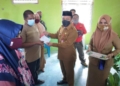 Sekda Boalemo Sherman Moridu SPd, MM menyerahkan buku tabungan PKH kepada masyarakat penerima manfaat.(F.HMS)