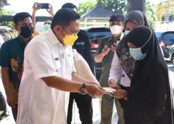 Walikota Gorontalo Marten Taha menyerahkan bantuan kepada masyarakat.(f.hms)