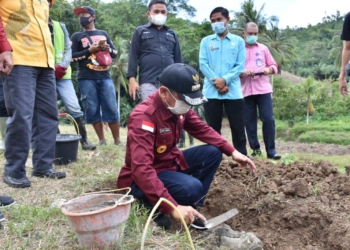 Bupati Pohuwato Saipul Mbuing melakukan peletakan batu pertama pembangunan tower di Desa Malango.(f.hms)