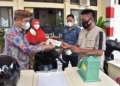 Bupati Pohuwato Saipul Mbuinga menyerahkan bantuan kepada pedagang ikan keliling.(f.hms)