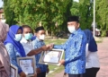 Plt Bupati Boalemo Anas Jusuf menyerahkan piagam penghargaan bagi ASN dinilai punya prestasi dan dedikasi tinggi.(f.istimewa)