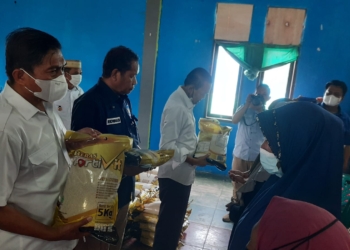 Haji Roni Imran saat menyerahkan bantuan beras kepada warga (foto : istimewa)