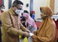 Wali Kota Gorontalo, Marten Taha saat menyerahkan paket logistik ke salah satu warga