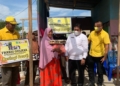 Ketua DPD Golkar Boalemo, Lahmudin Hambali didampingi Camat Wonosari, Lukman Amu menyerahkan bantuan kepada keluarga korban bencana angin puting beliung.(F.Istimewa)