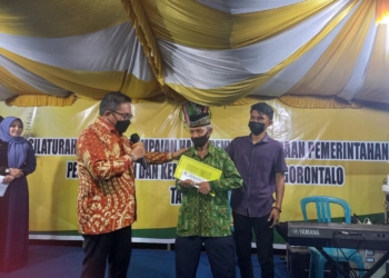 Wali Kota Gorontalo menyerahkan secara simbolis paket Umroh gratis ke Imam Masjid Al-Jariyah Dungingi. (f. anq/nn)