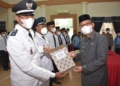 Plt Bupati Gorontalo Utara Thariq Modanggu saat menyerahkan SK kepada penjabat kepala desa. (f.ist)