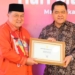 Penjabat Bupati Boalemo, Dr. Drs. Hendiwan, MSi menrima piagam penghargaan dari Kemenkes RI terkait keberhasilan mencegah penularan penyakit malaria.(F.Dok.Pimpinan)
