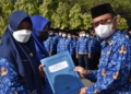 Penyerahan SK kepada CPNS dan PPPK formasi tahun 2021 yang secara simbolis diserahkan Plt Bupati Gorut, Thariq Modanggu kepada perwakilan CPNS dan PPPK di sela-sela apel Korpri, Selasa (17/5). (Foto : hmskominfo_gorut)