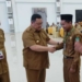 Penjabat Bupati Boalemo, Hendriwan menyematkan tanda peserta para guru dan kepala sekolah pada Workshop Inovasi Pendidikan One School One Inovasi digagas Dikpora Boalemo.(f.dok.humas)