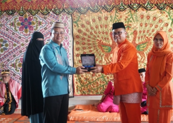 Bupati Gorontalo Utara Thariq Modanggu memberikan cenderamata kepada pejabat lama Kapolres Gorut AKBP Juprisan Pratama Ramadhan Nasution. (foto.ist)