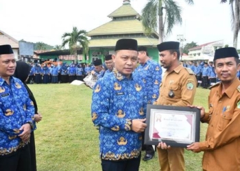 Pj. Sekda Boalemo, Supandra Nur menyerahkan piagam penghargaan kepada kepala desa yang berhasil menyelesaikan perekaman e-KTP mencapai 100 persen.(f.dok.hms)