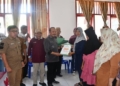 Penjabup Boalemo, Sherman Moridu didampingi Ketua Baznas, Mus Moha bersama Ketua DPRD Boalemo, Karyawan Eka Putra Noho saat memberikan bantuan kepada masyarakat di Kecamatan Mananggu.(f.dok.hms)