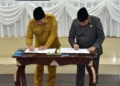 Penjagub Ismail Pakaya menandatangani nota kesepahaman bersama Ketua DPRD Paris R.A Jusuf tentang Ranperda RTRW pada rapet paripurna, Senin (19/2/2024). (F. Fadil)