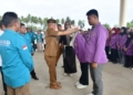 Bupati Saipul A. Mbuinga menyematkan tanda peserta KKN kepada dua perwakilan mahasiswa.