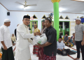 Wabup Boalemo, Lahmuddin Hambali menyerahkan paket bantuan dari Baznas kepada masyarakat membutuhkan.(f.dok.pimpinan)