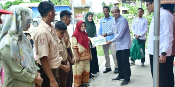 Sekda Iskandar saat mewakili Bupati Saipul Mbuinga menyerahkan bantuan dari BAZNAS untuk masyarakat penerima manfaat